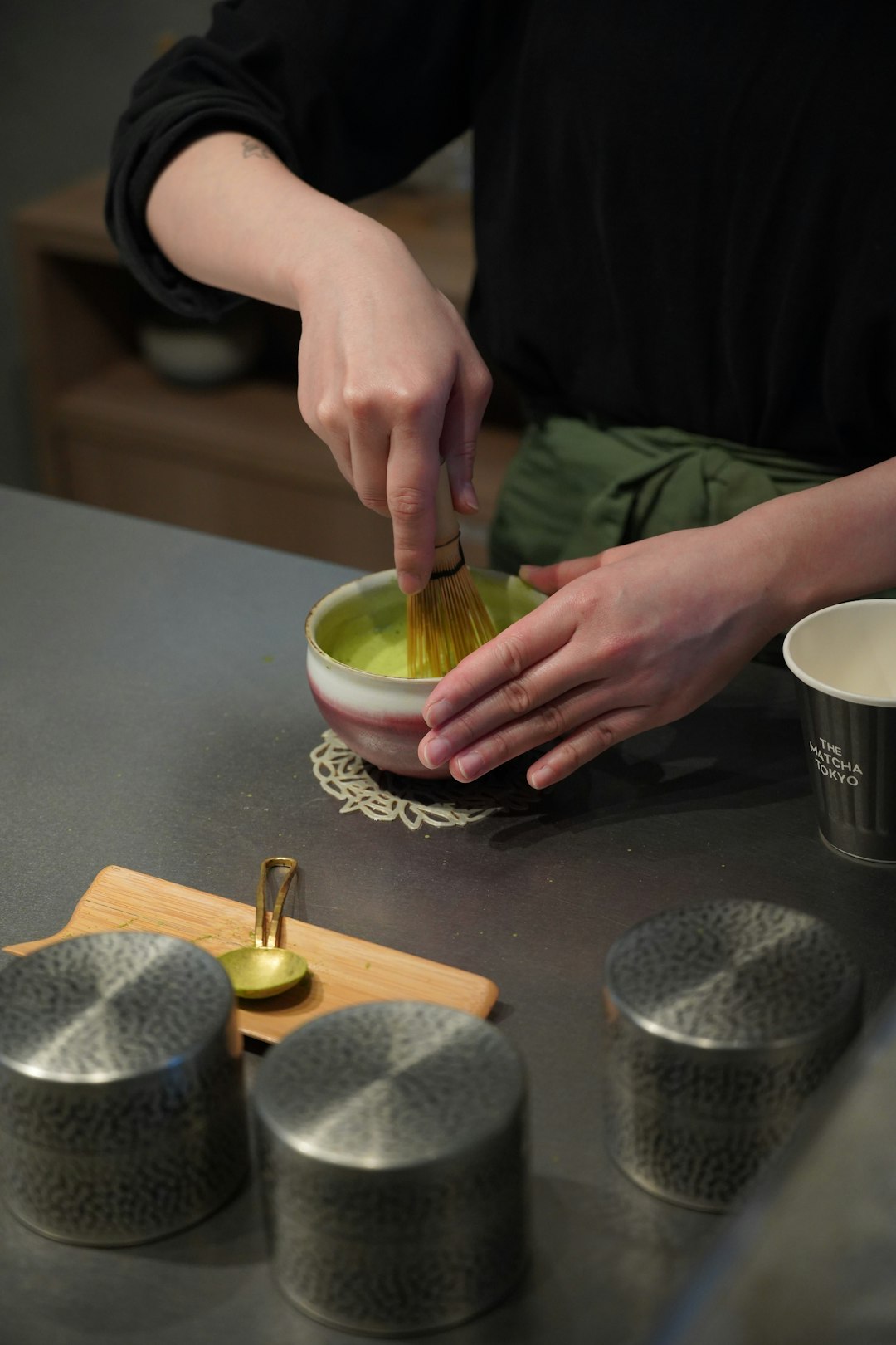 Chasen de bambú batiendo matcha en un cuenco de cerámica